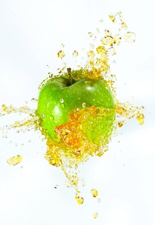 Freeze motion of sliced green apple with splashing juice.の写真素材