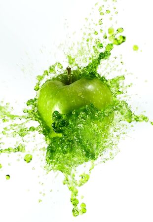 Freeze motion of sliced green apple with splashing juice isolated on white backgroundの写真素材