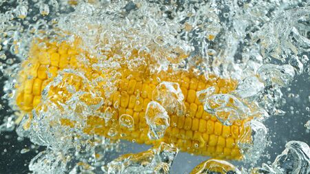 Throwing corn into boiled water, freeze motion.の写真素材