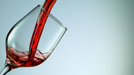 red wine pouring into wine glassの写真素材
