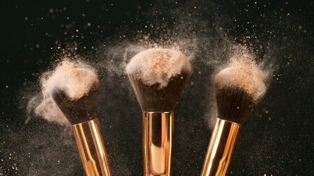 Makeup brushes touch each other on dark backgroundの写真素材