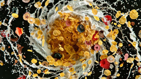 Freeze motion of rotating cereal pieces with milk splashの写真素材