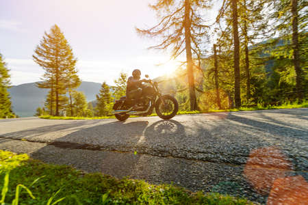 Motorcycle rider driving in Alps, beautiful nature with clear sky.の写真素材