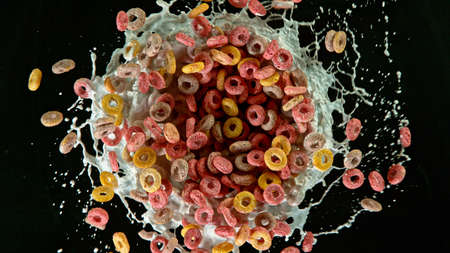 Freeze motion of rotating cereal pieces with milk splashの写真素材