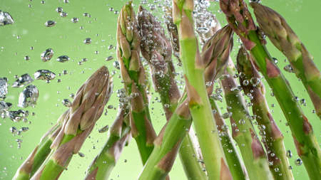 asparagus in water with splashesの写真素材