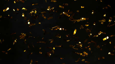 Abstract falling gold confetti on black background.