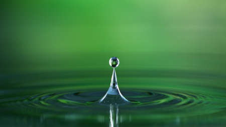 Water splash isolated on green backgroundの写真素材