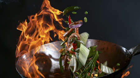 Freeze Motion of Wok Pan and Flying Ingredients in the Air.の写真素材