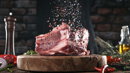 Close-up of falling salt and pepper on tasty beef steakの写真素材