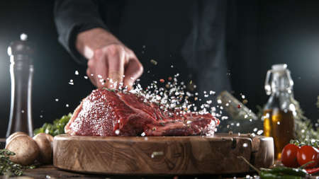 Close-up of falling salt and pepper on tasty beef steakの写真素材