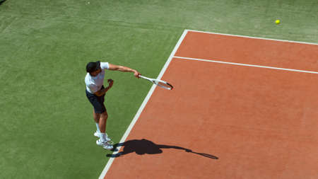 Freeze motion shot of tennis player hitting the ballの写真素材