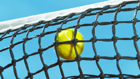 Freeze motion shot of tennis ball hitting the netの写真素材