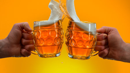 Freeze motion of beer glasses in cheers gesture, close-up