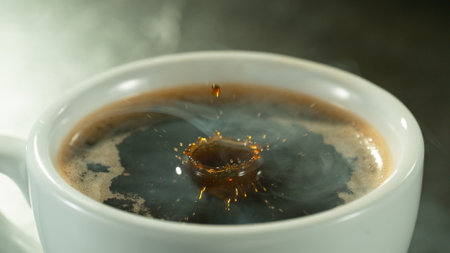 Macro Shot of Coffee Drop Falling into Fresh Espresso Cup