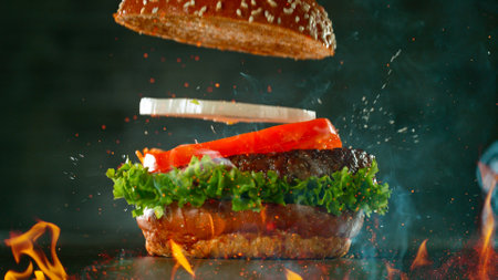 Beef Burger with Ingredients Falling and Landing in the Bunの写真素材