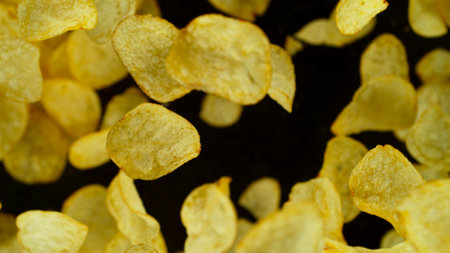 Potatoes fried chips in freeze motion, isolated on black background