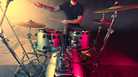 A drummer plays on a dark stage in the fogの写真素材