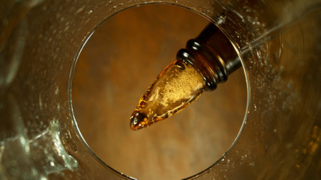 Freeze motion of pouring beer into pint. Unique angle of view from the bottom of the glass.の写真素材