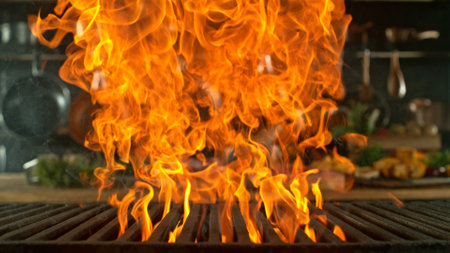Close-up of cast-iron grate with fire flames, dark backgroundの写真素材