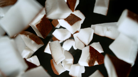Fresh coconut pieces falling into water, top down viewの写真素材