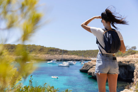 A young woman watching the surface of the sea. The concept of active travel.の写真素材