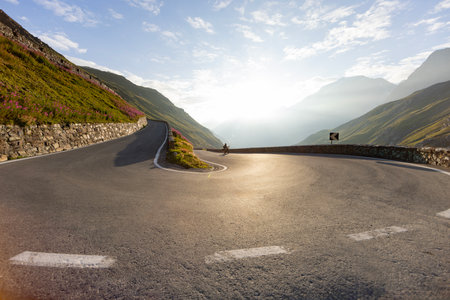Motorbiker riding in Italian Alps during sunrise, dramatic sky. Travel and freedom, outdoor activitiesの写真素材