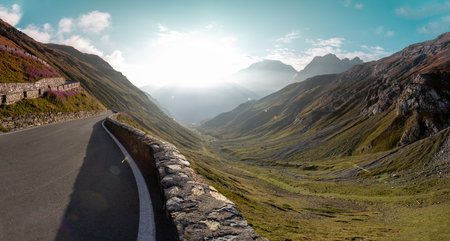 Motorbiker riding in Italian Alps during sunrise, dramatic sky. Travel and freedom, outdoor activitiesの写真素材