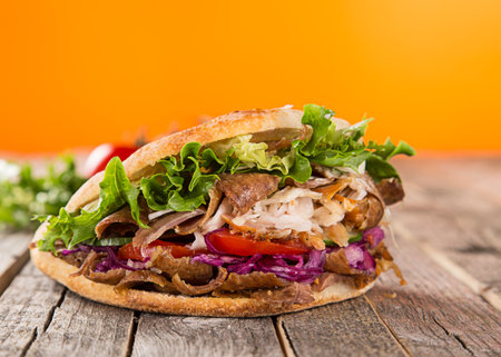 Doner Kebab Doner Kebap fast food snack in flatbread on a wooden tableの写真素材