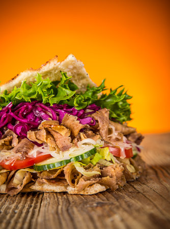 Doner Kebab Doner Kebap fast food snack in flatbread on a wooden tableの写真素材