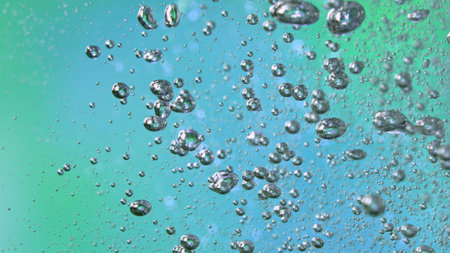 Freeze Motion Shot of Moving Bubbles on Green and Blue Backgroundの写真素材