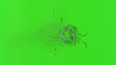 Close-up of a bullet impact on glass, shattering against a green background