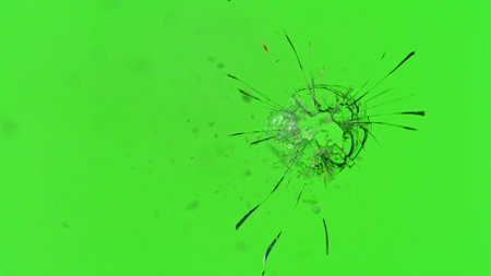 Close-up of gunshot through the glass, shattering against the green backgroundの写真素材