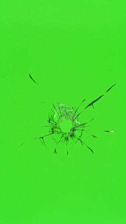 Close-up of a shattered glass against a green background