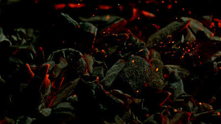 Close-up of Hot Embers with Flying Sparks . Concept of heating grills or ovensの写真素材