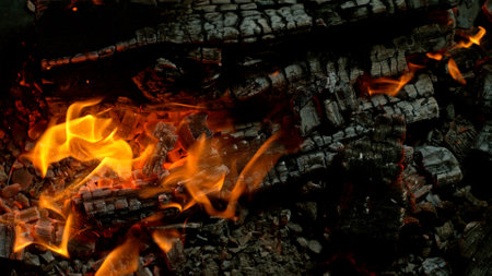 Close-up of Hot Embers with Flying Sparks . Concept of heating grills or ovens