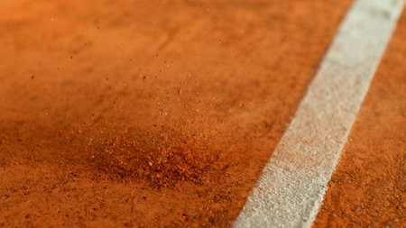 Freeze Motion Detail Shot of Tennis Ball Hitting a Clay Courtの写真素材