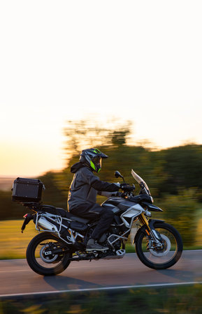Person riding motorcycle on road during sunsetの写真素材