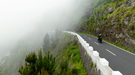 Motorcycle Rider Driving in High Mountain Landscape, Madeira Island , Portugalの写真素材