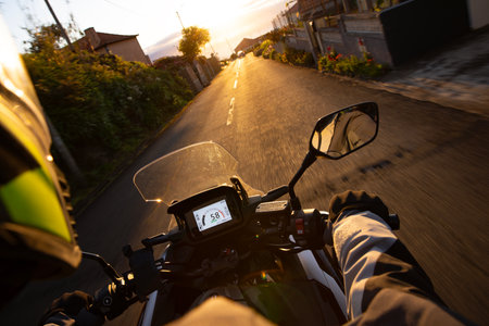 Driver riding motorcycle on empty asphalt road, handlebars view , spring mountainsの写真素材