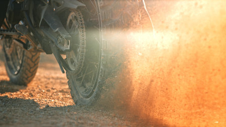 Flying rocks and dust from the wheel of a motocross bike at the start of the raceの写真素材