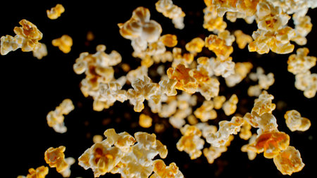Freeze Motion of Popcorn Falling on Black Backgroundの写真素材