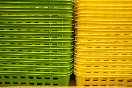 Colorful plastic boxes stacked one upon the other. Multi-colored plastic baskets on the store shelf.の写真素材
