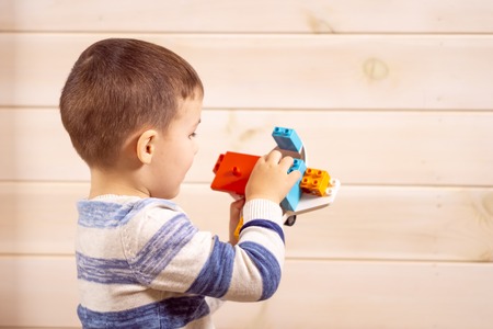 little boy plays with toy car at home