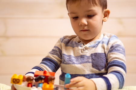 little boy plays with toy car at homeの写真素材