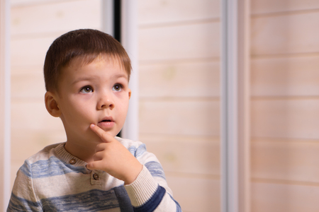 A boy of three years old posing in front of the camera on a white background.の写真素材