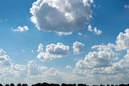 Beautiful blue sky with white clouds and a thin horizon line. Rays The sun breaks through the...