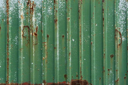 Green rusty metal fence. Corrugated metal sheet. Wall of green freight container. Vintage creative backgroundの写真素材