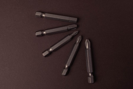Bits bits for tightening screws of different sizes on a brown background