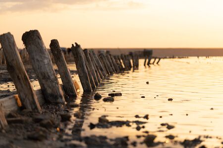 Sunset on the Kuyalnik Liman. Odessa. Ukraine. Old logs are visible from the water - the remains of an ancient pierの写真素材