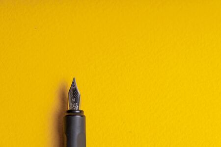 Fragment of an ink pen on a yellow background. Copyspaceの写真素材